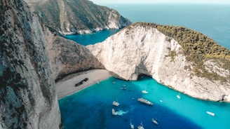 aerial view of boats on sea near brown mountain during daytime