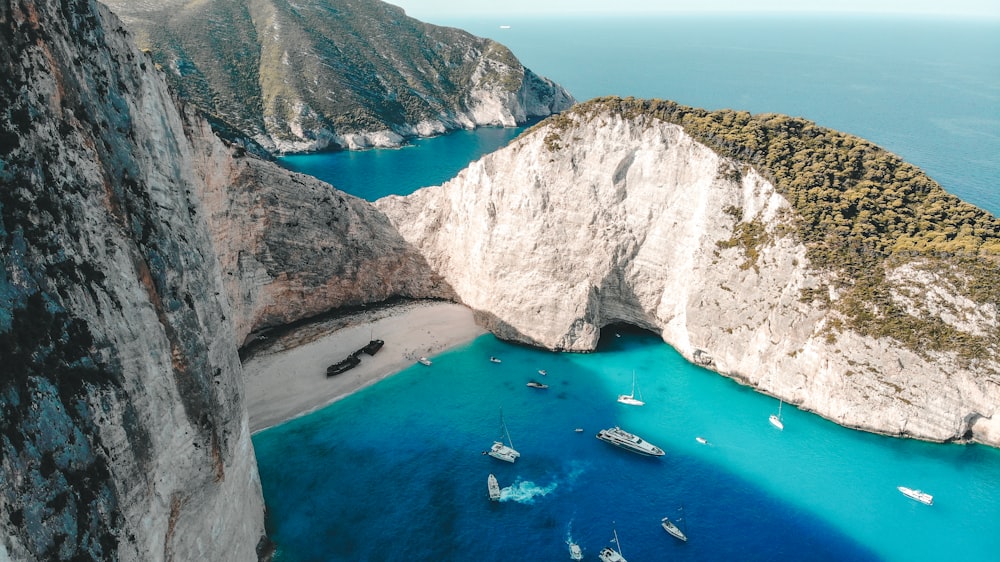 aerial view of boats on sea near brown mountain during daytime