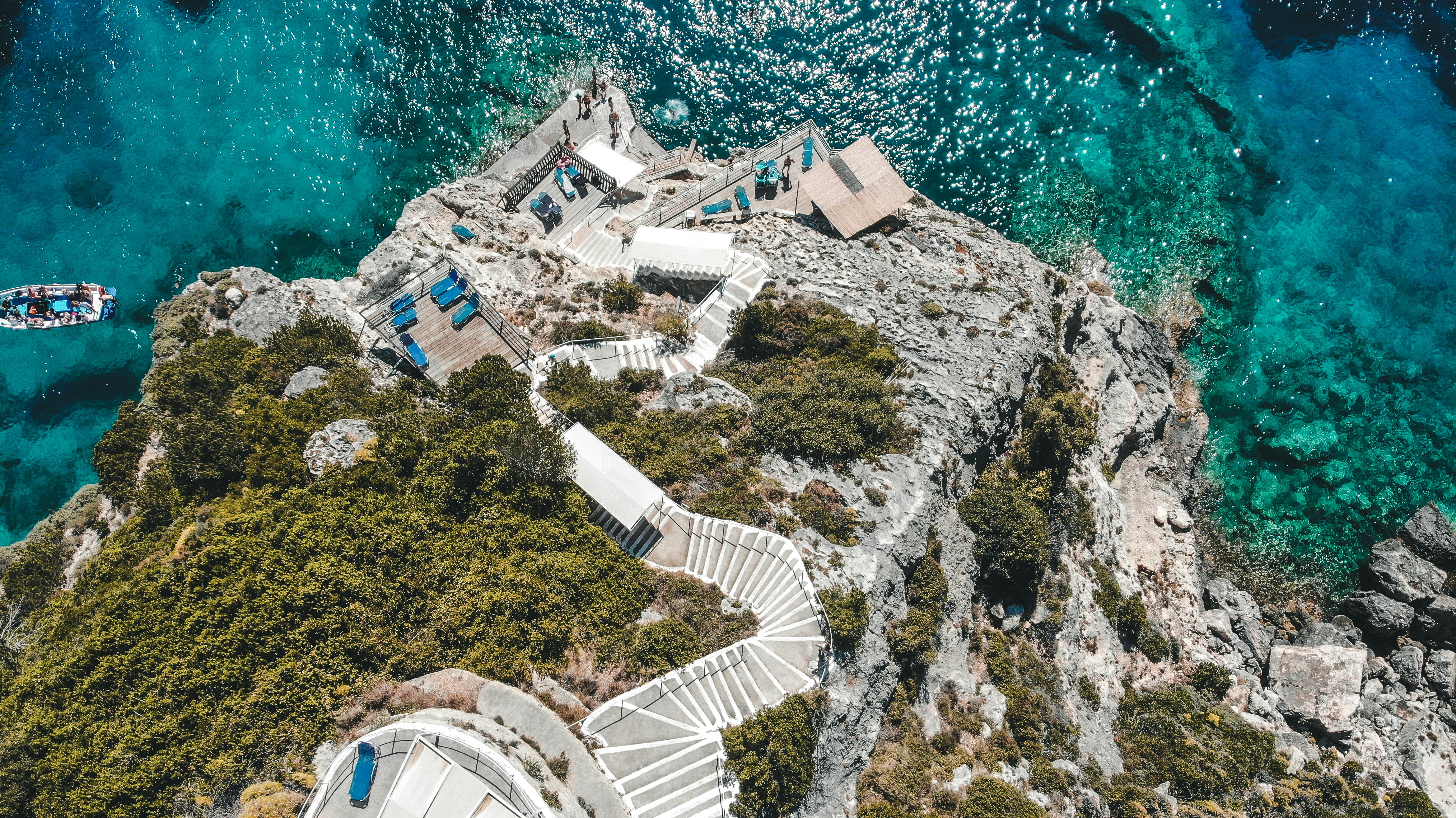 aerial view of white concrete building near body of water during daytime