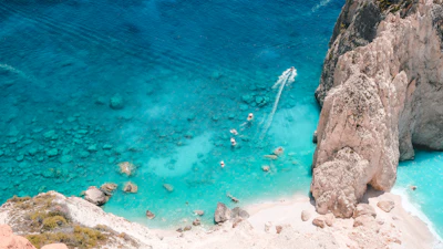 Swimmers in the turquoise water under the white cliffs of Zakynthos