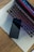 A sleek smartphone is placed on the touchpad of a laptop with a colorful backlit keyboard. The laptop rests on a wooden surface, and the screen displays a gradient of colors.