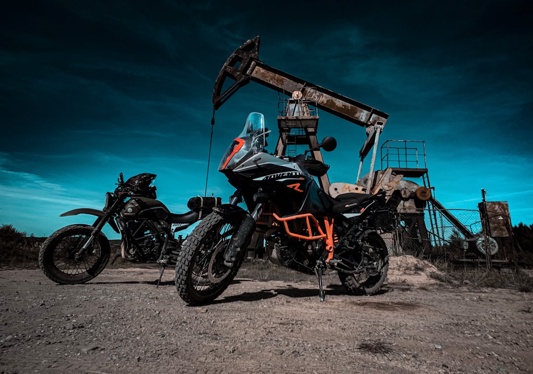 black and orange motorcycle near brown wooden building