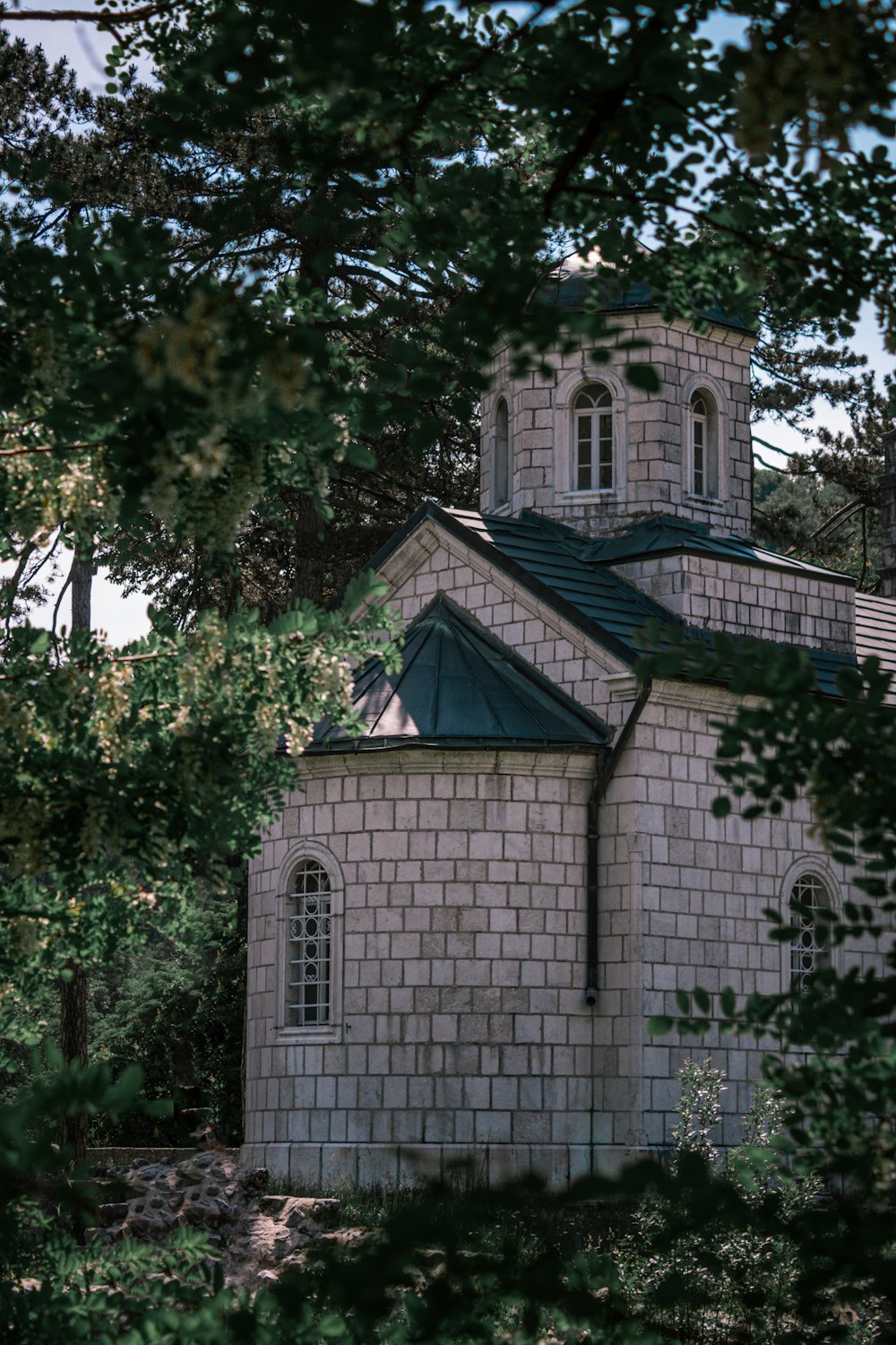 Bâtiment en béton blanc et brun près de l’arbre vert pendant la journée