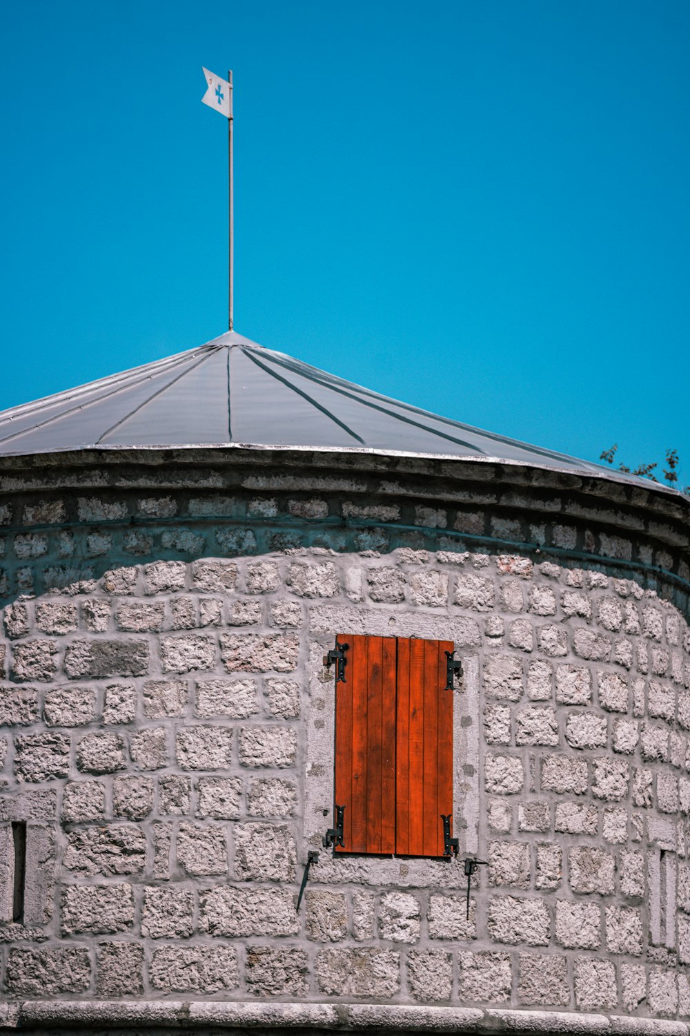 Porta di legno marrone su muro di mattoni grigi