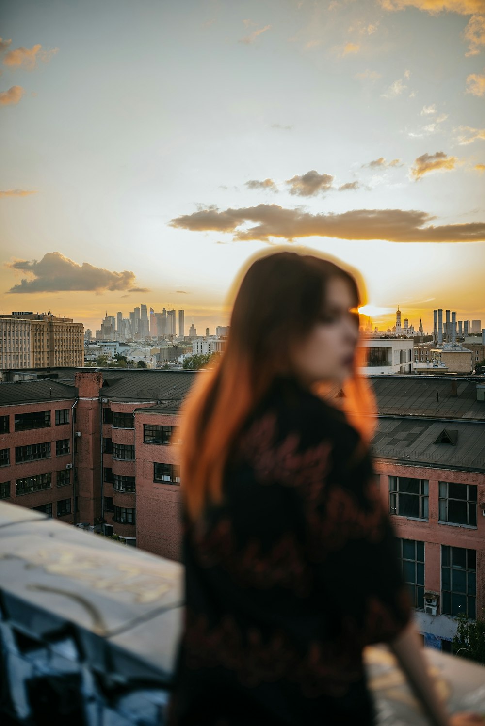 woman in black jacket standing on top of building during daytime