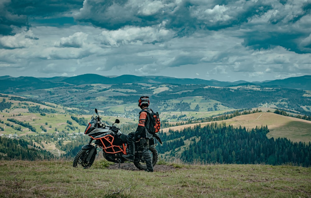 man in black jacket riding black motorcycle on green grass field during daytime