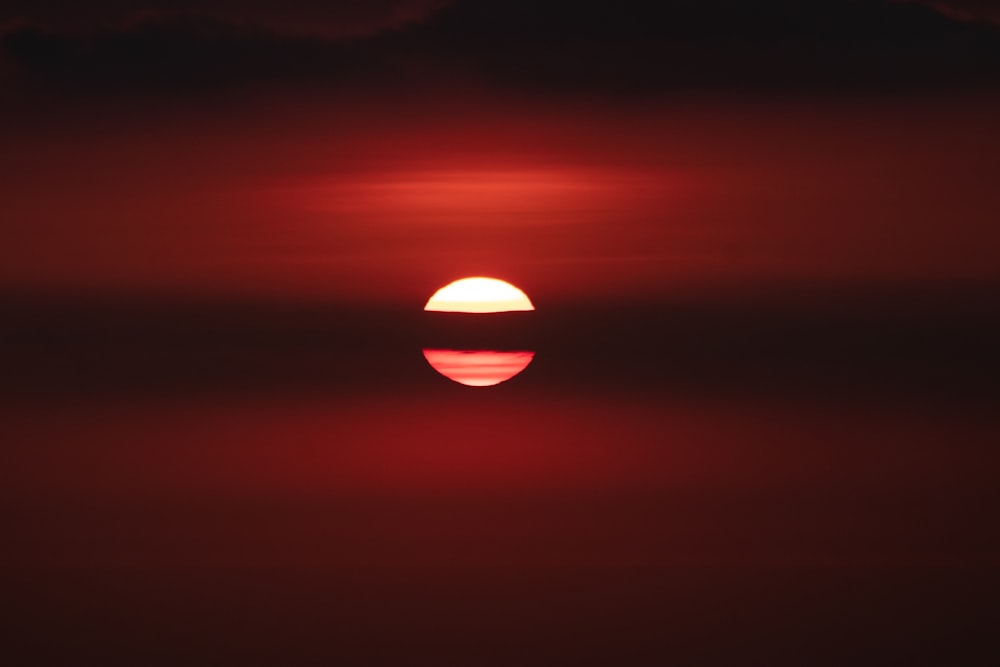 地平線に沈む赤とオレンジの夕日