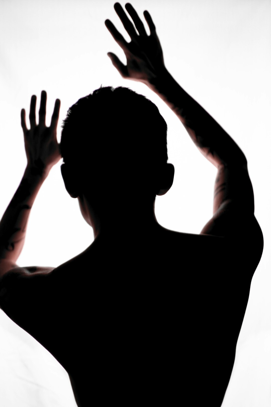 silhouette of man raising his hands