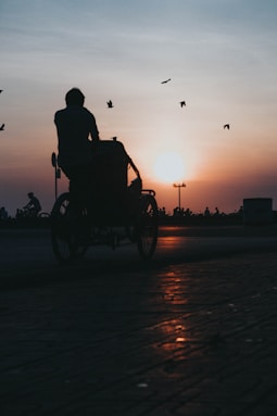 silhouette of man riding on motorcycle during sunset