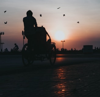 silhouette of man riding on motorcycle during sunset