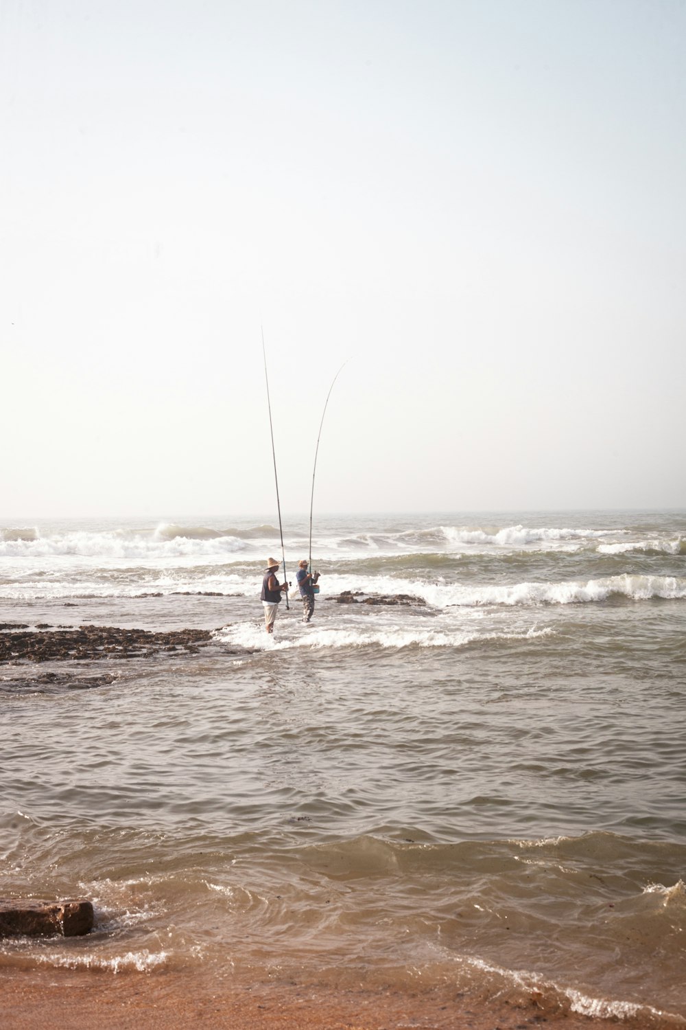 2 person surfing on sea during daytime