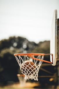 Close-up of a basketball swishing through a net during a game.
