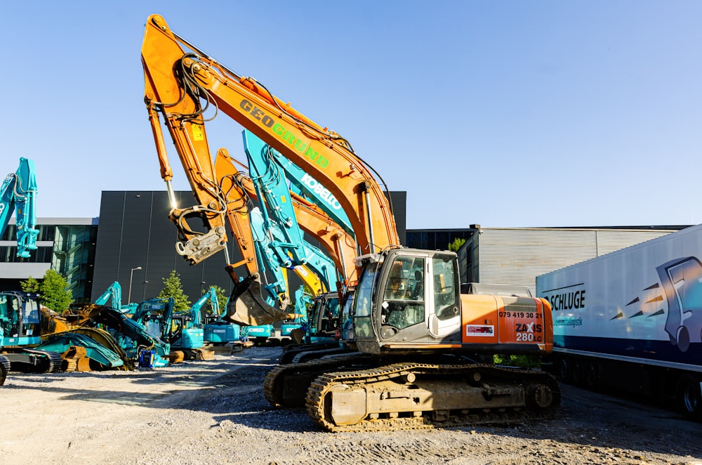 orange-weißes schweres Gerät tagsüber auf grauem Betonboden