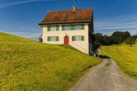 red and white concrete building near green grass field during daytime