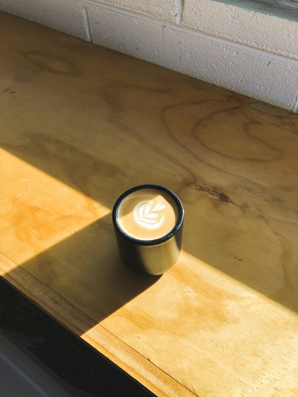 black and white ceramic mug on brown wooden table