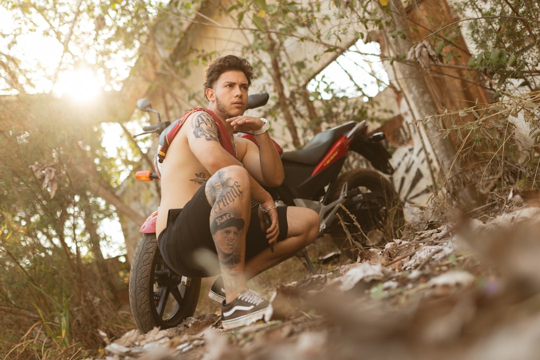 woman in red tank top sitting on black motorcycle