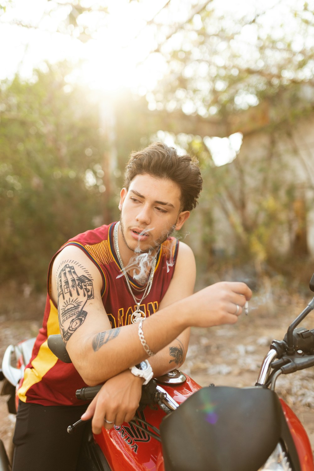 woman in red and yellow sleeveless shirt sitting on motorcycle