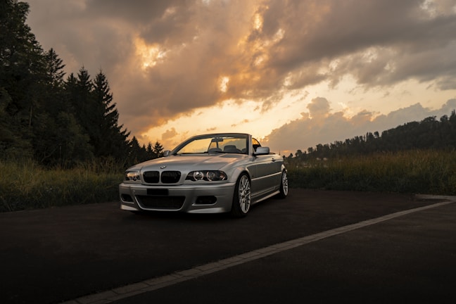 A professional photo shoot setup capturing a premium convertible at sunset.
