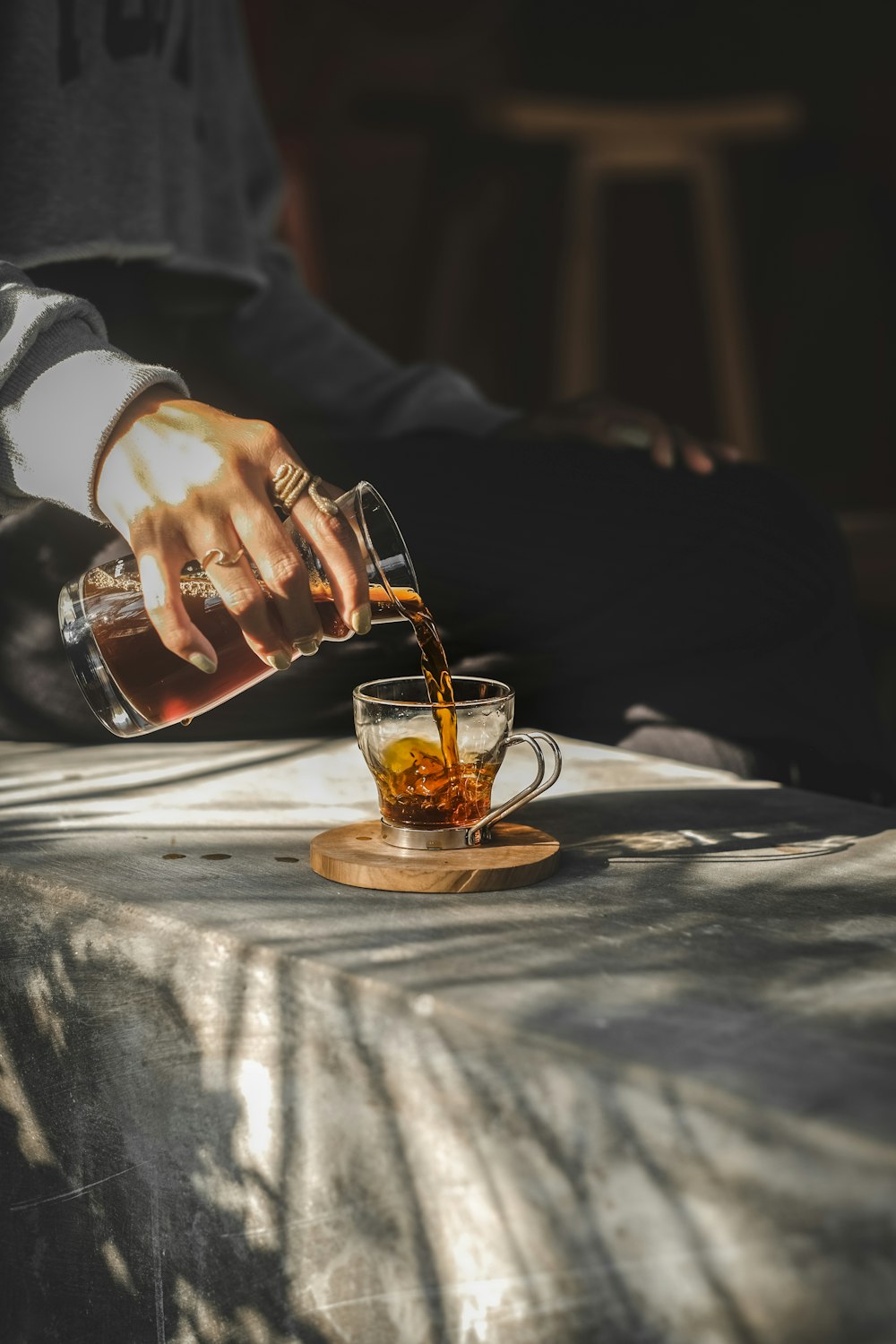 person holding clear glass mug with brown liquid