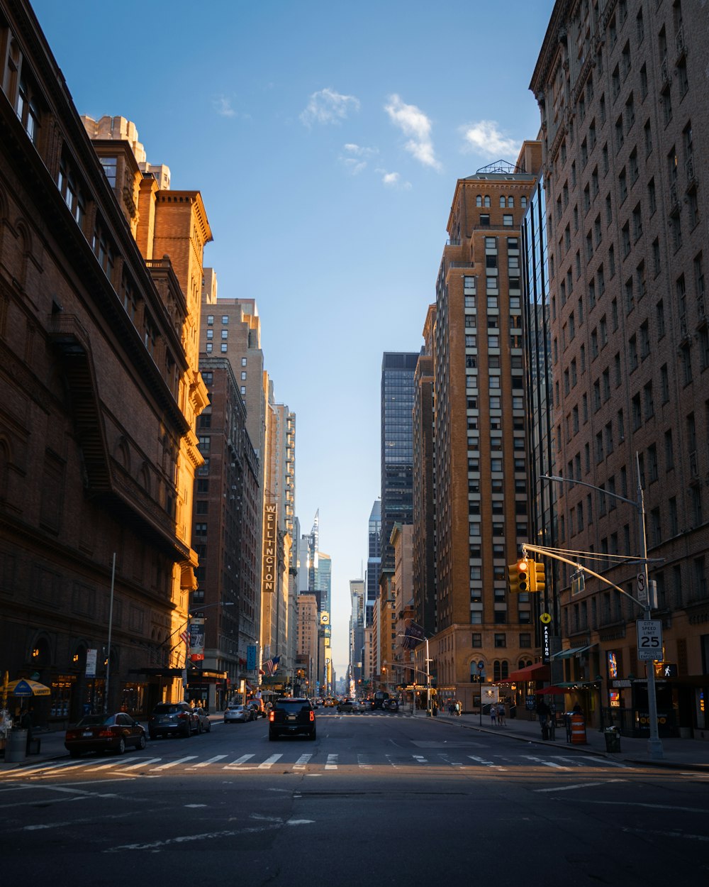 cars on road between high rise buildings during daytime