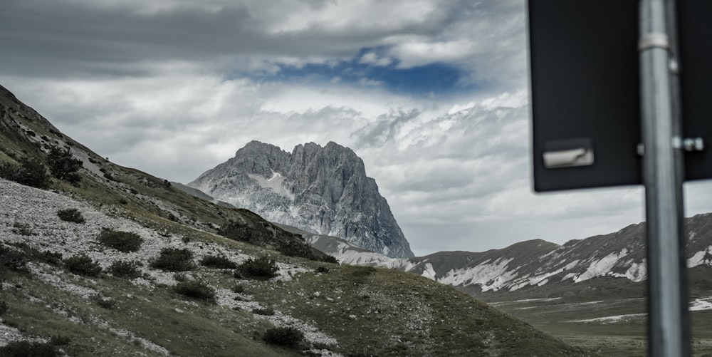 gray and white mountain under white clouds and blue sky during daytime