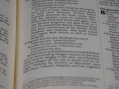 A close-up view of a page from a book with text describing genealogy. The text includes names and familial relationships written in a traditional serif font. The layout is typical of a religious or historical text with numbers denoting verses or sections.