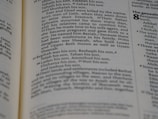 A close-up view of a page from a book with text describing genealogy. The text includes names and familial relationships written in a traditional serif font. The layout is typical of a religious or historical text with numbers denoting verses or sections.