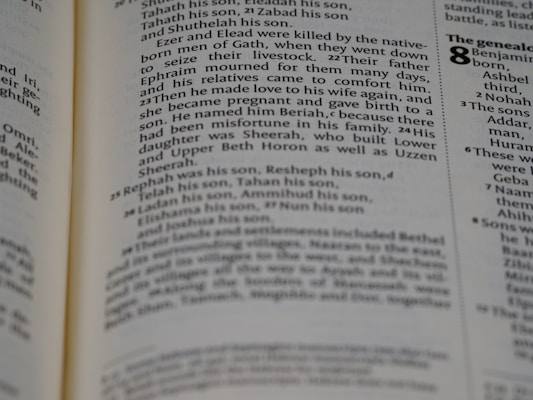 A close-up view of a page from a book with text describing genealogy. The text includes names and familial relationships written in a traditional serif font. The layout is typical of a religious or historical text with numbers denoting verses or sections.