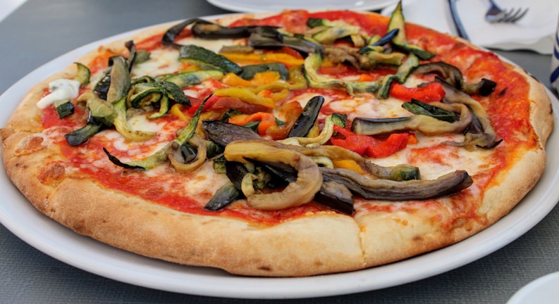 A freshly baked pizza topped with vibrant vegetables and cheese.