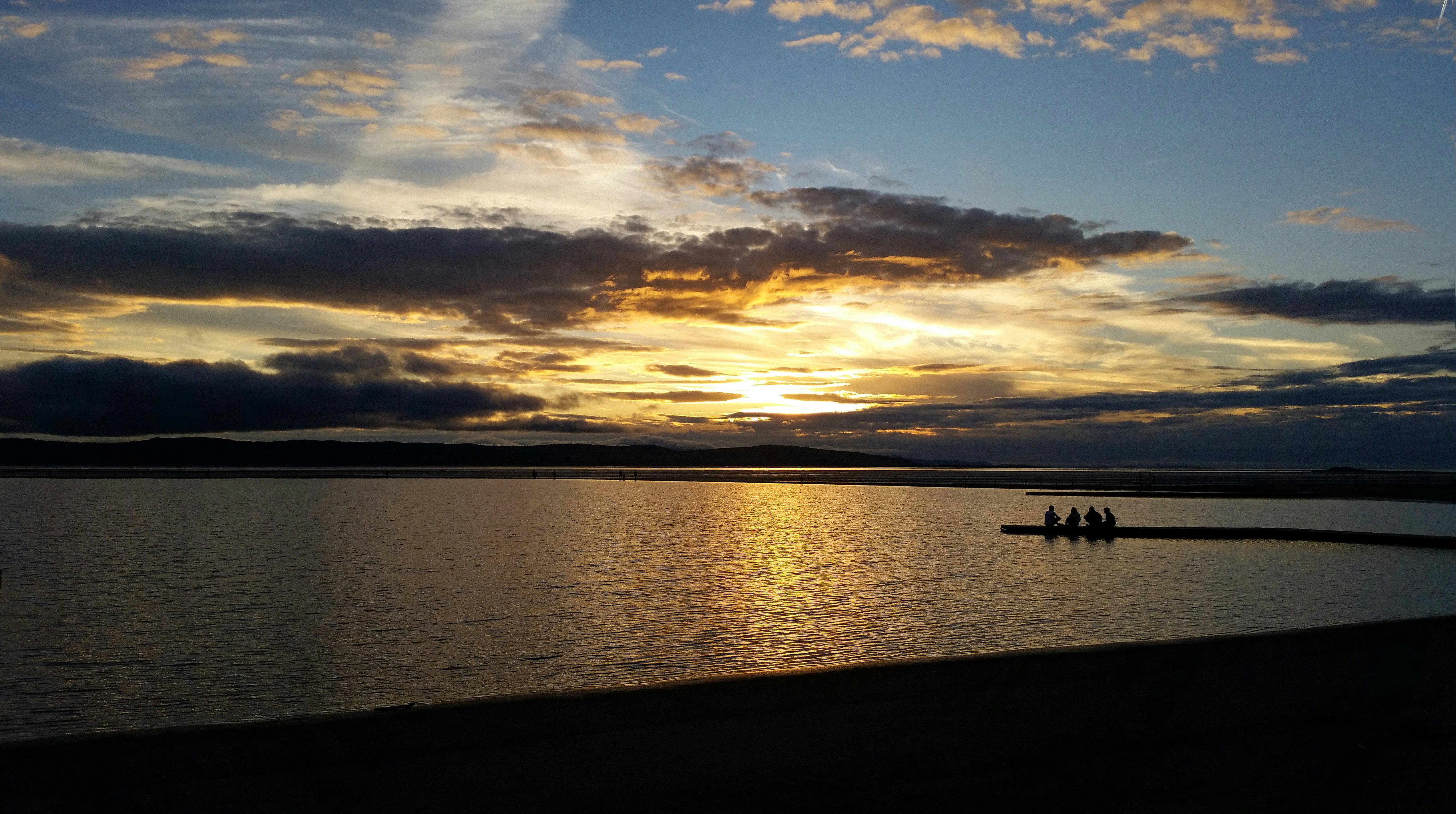 silhouette of people on boat on sea during sunset