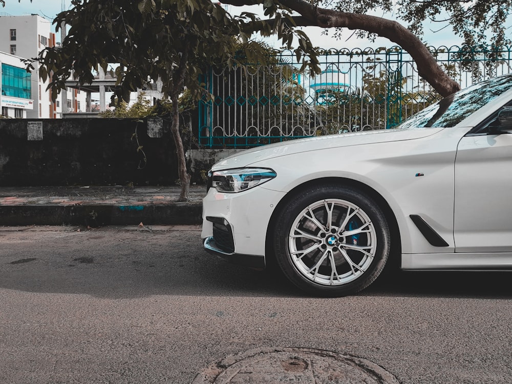 white car parked near blue metal gate during daytime