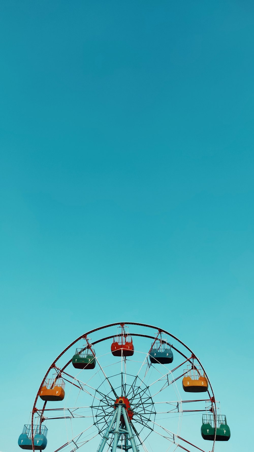 red and white ferris wheel under blue sky during daytime