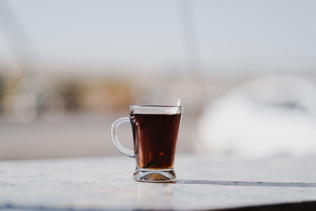 clear glass mug with brown liquid