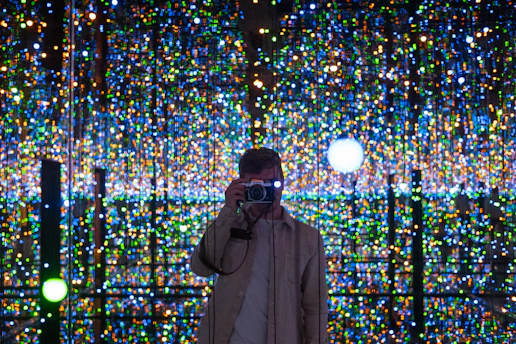 A circular magic photo booth glowing with colorful lights and guests posing inside.