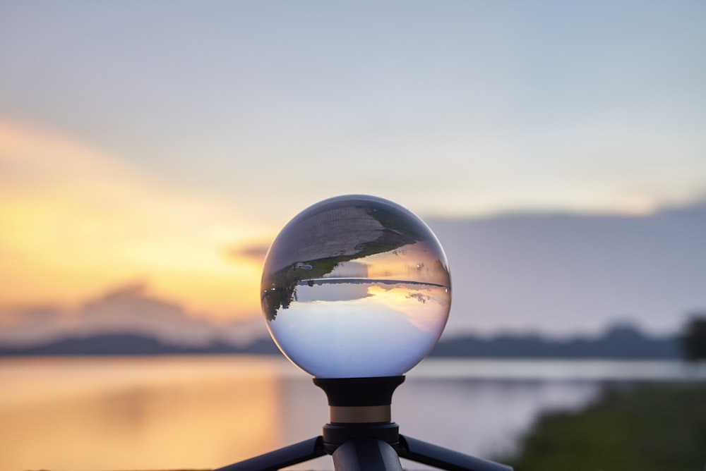 clear glass ball on black metal fence during daytime