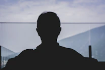 man in black shirt standing near body of water during daytime