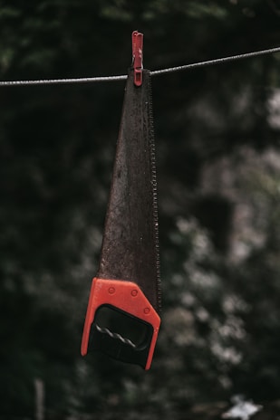 A durable hand saw with a bright yellow handle, showcased on a plain white surface.