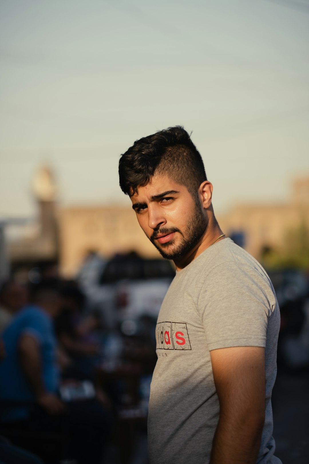 man in gray crew neck t-shirt standing near people during daytime