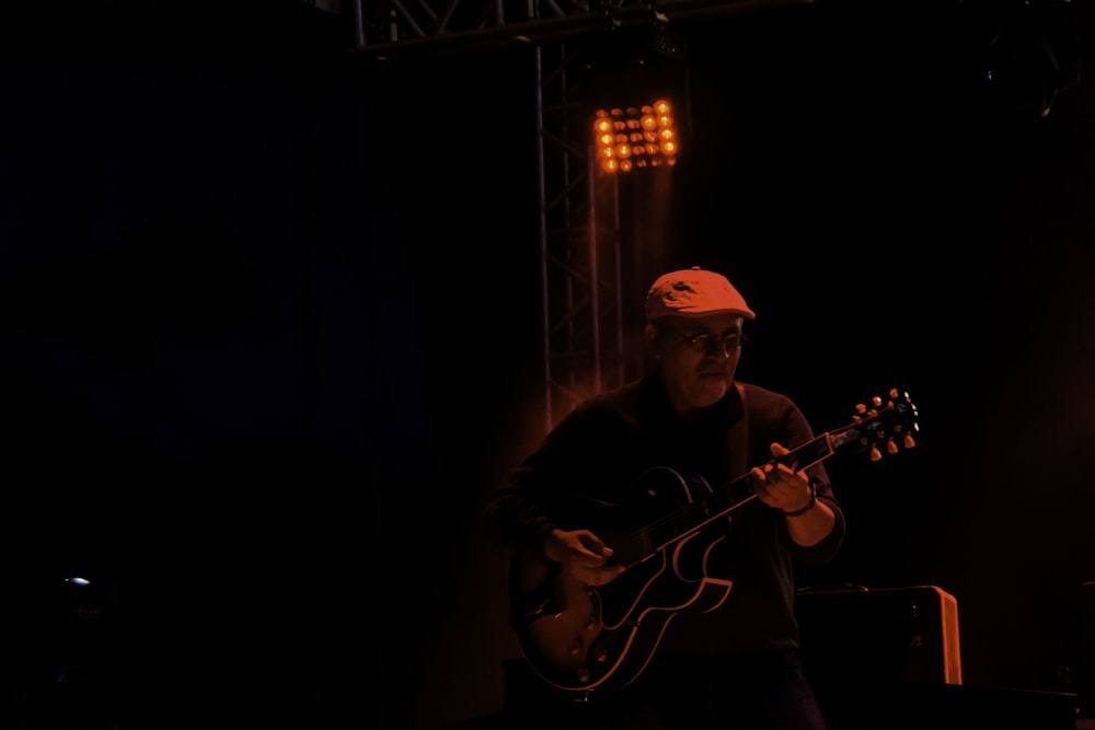 man in black shirt playing guitar