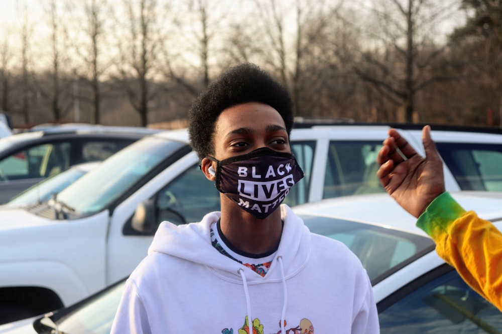 man in white crew neck t-shirt with black and white face mask