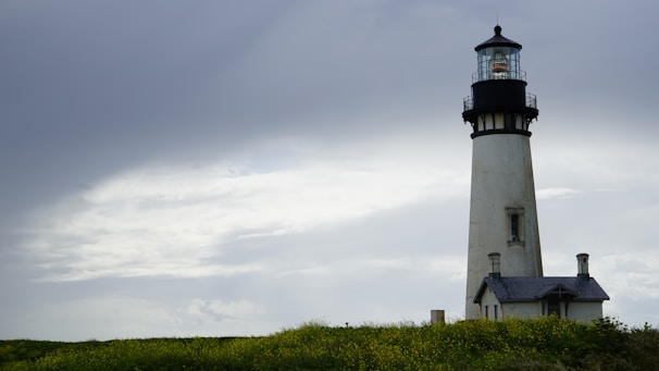 A calm lighthouse standing firm against a bright sky, symbolizing guidance and protection.
