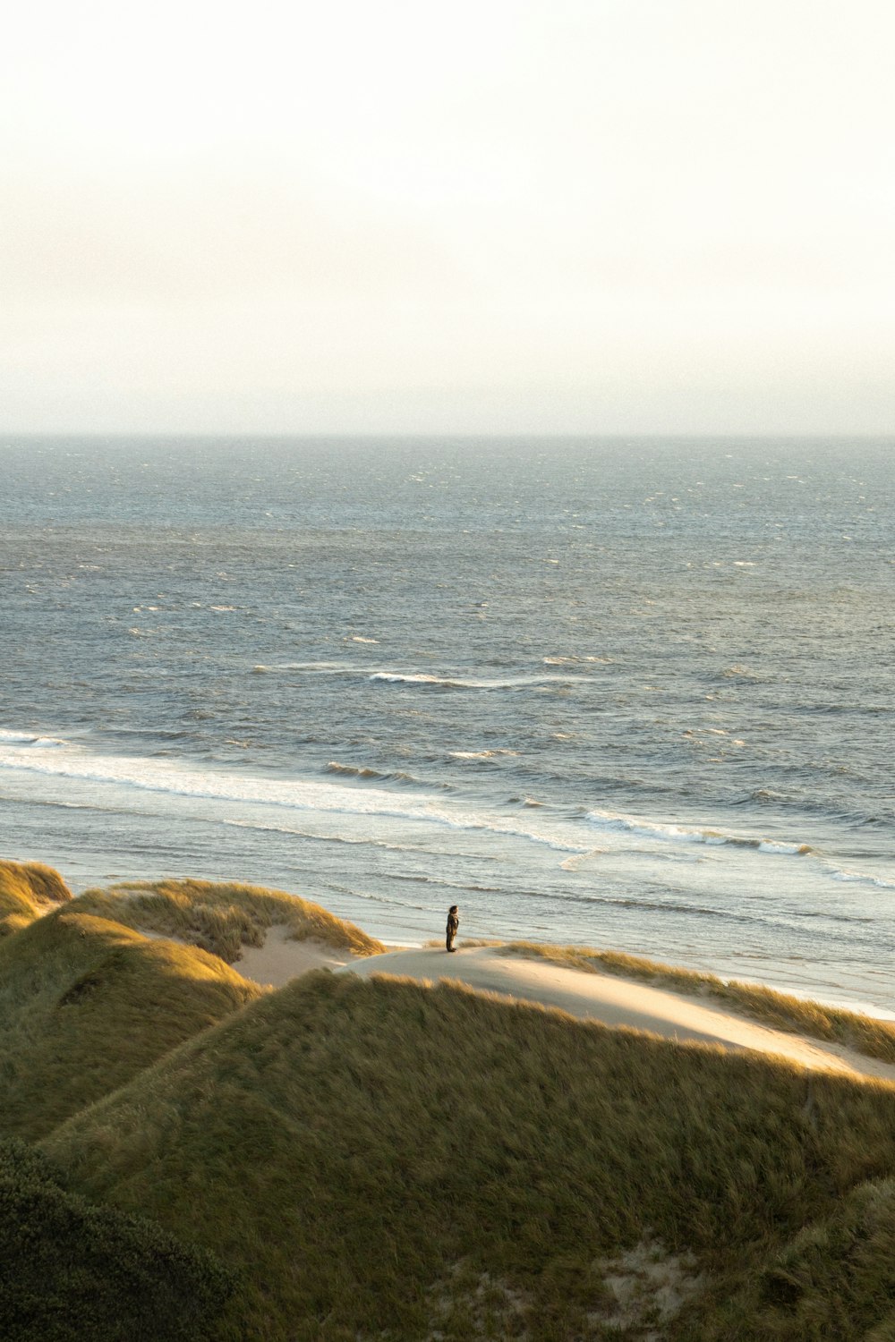 person standing on rock near body of water during daytime