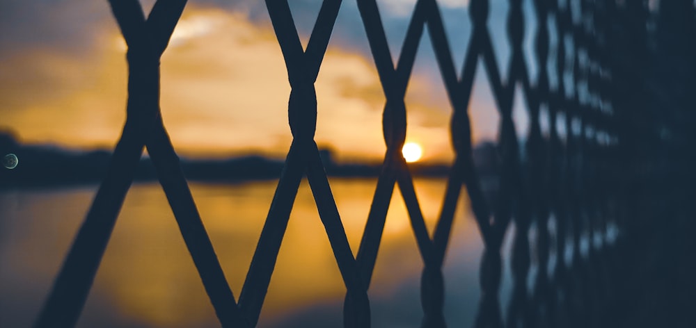 silhouette of metal fence during sunset