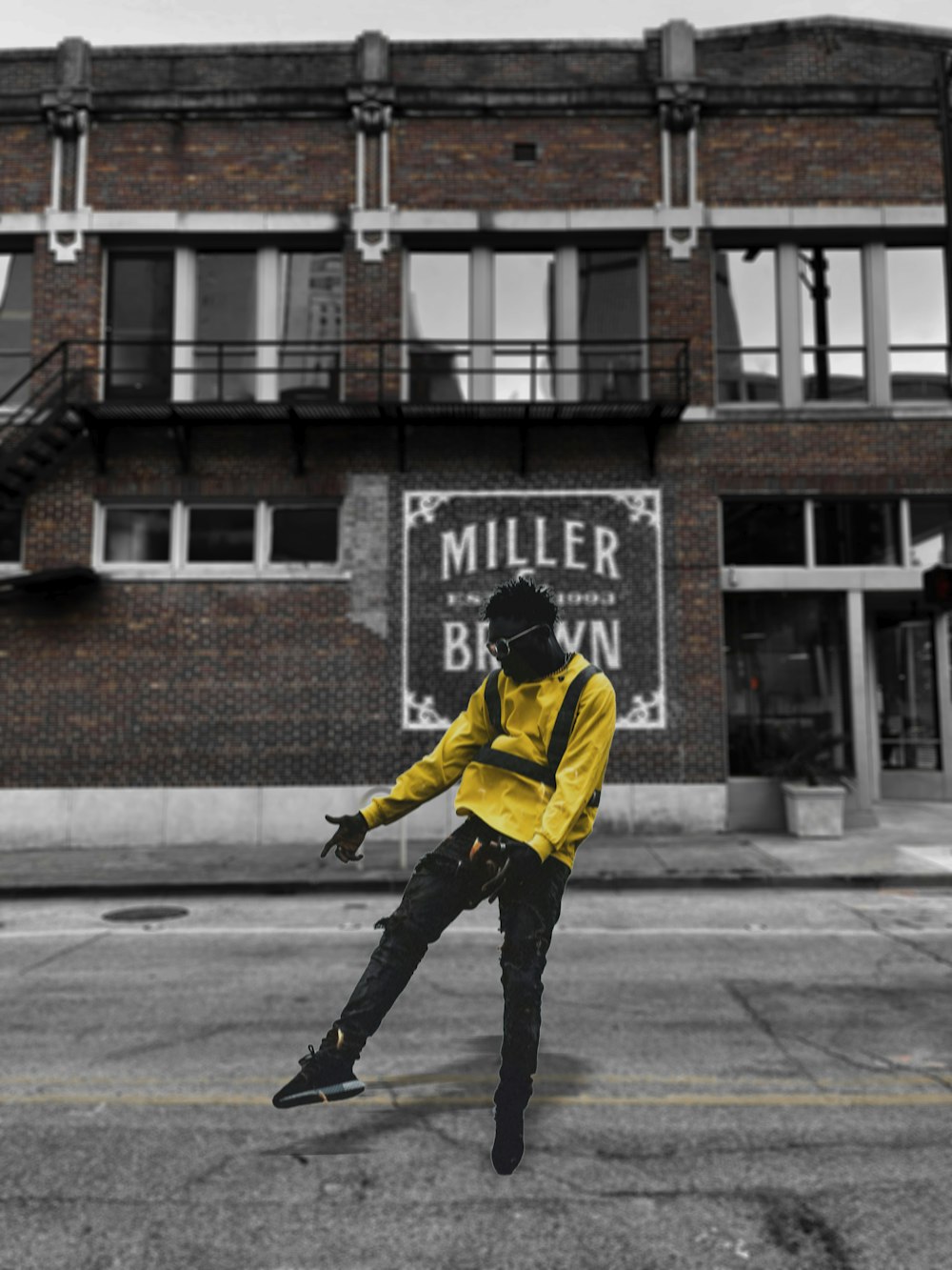 man in yellow and black jacket and black pants walking on sidewalk during daytime