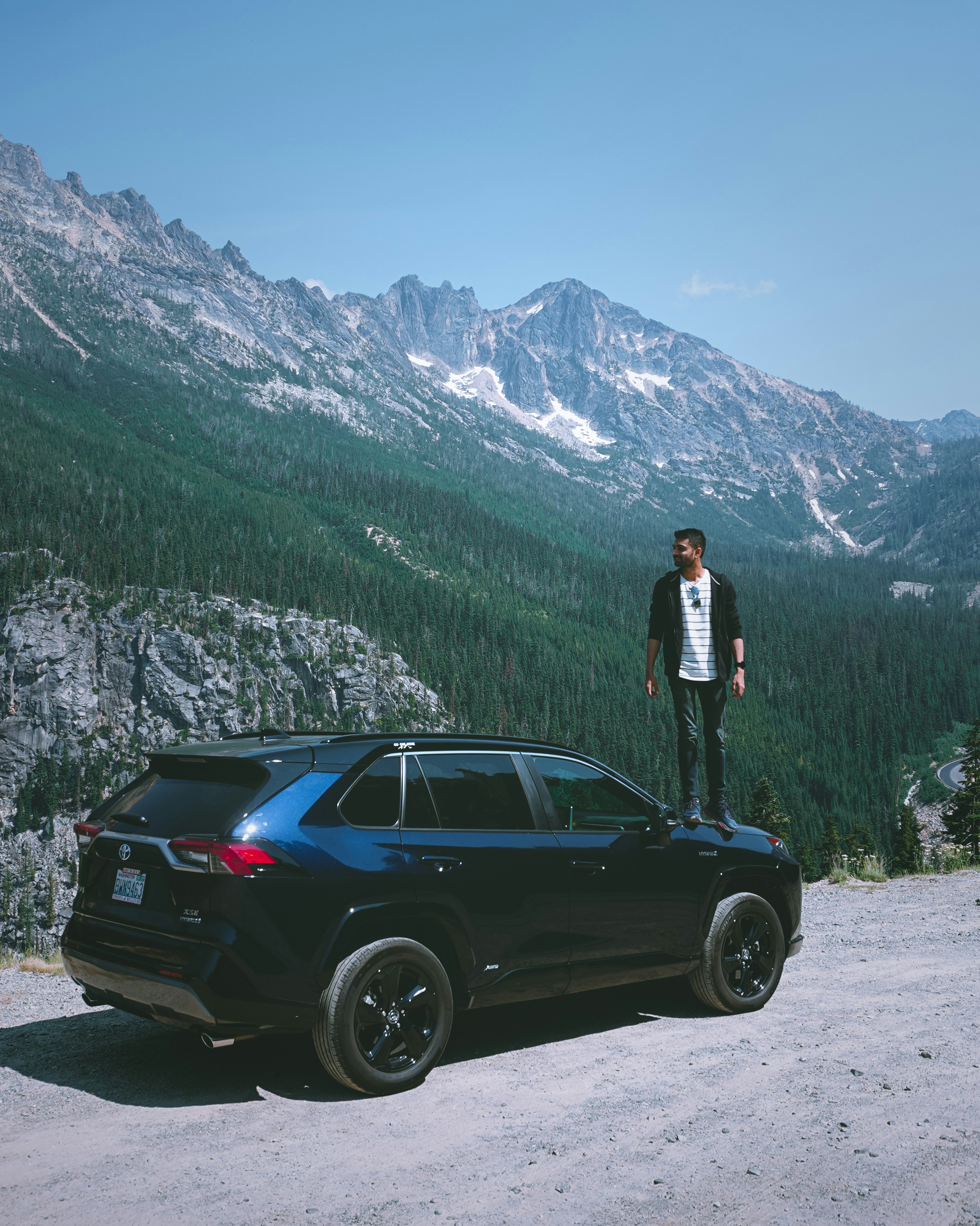 woman in black jacket standing beside black car during daytime