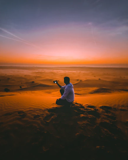A photographer capturing a sunset over the sand dunes of Merzouga desert.