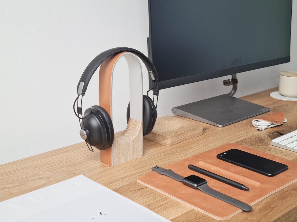 black and silver headphones on brown wooden desk