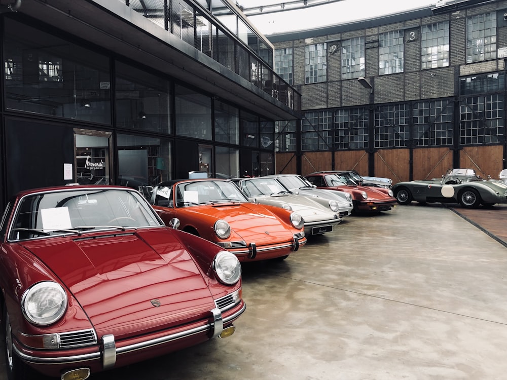 red and black cars parked beside building during daytime