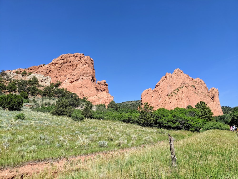 brown rock formation on green grass field during daytime