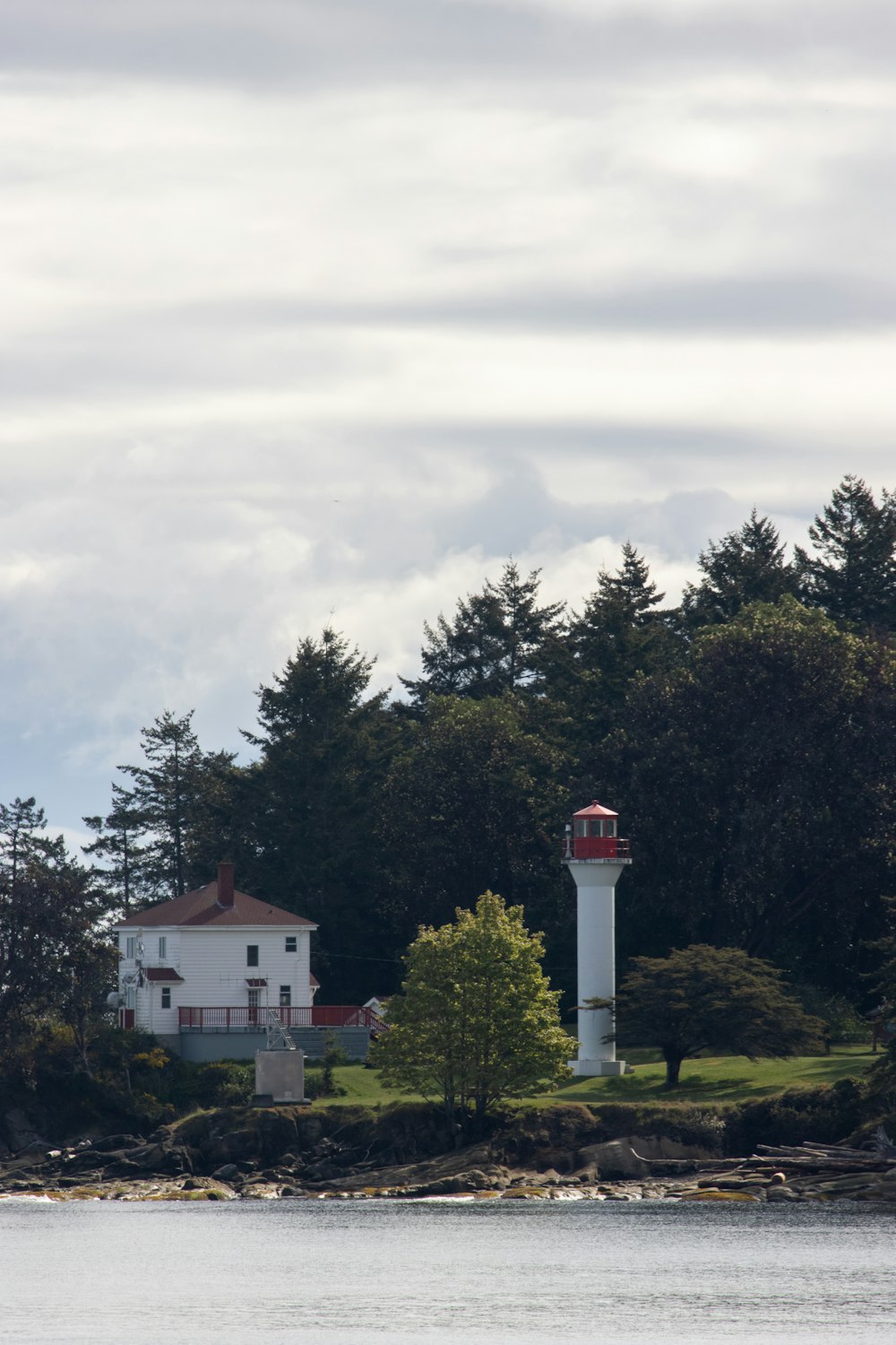 white and red concrete building near green trees under white clouds during daytime